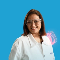 A BASF employee from India standing in a white lab coat against a blue background, a light swirl hovers around the shoulder.