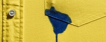 Blauer Fleck auf gelber Hemdtasche