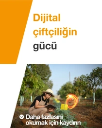 Tulum ve şapka giyen bir kadın çiftçi bir tablet tutuyor ve güneşli bir günde tarladaki bitkileri inceliyor. Görüntünün sol tarafında şu yazı yer alıyor: “Dijital çiftçiliğin gücü.”
