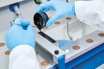 Für die Herstellung von kleinen Testbatterien gießt eine wissenschaftliche Mitarbeiterin von BASF eine Paste aus Kathodenmaterial auf eine Aluminiumfolie. Anschließend wird die gegossene Folie getrocknet und verdichtet. Sie wird später als Kathode (Pluspol) in einer Lithium-Ionen-Batterie verbaut.
For the production of small test batteries, a scientist of BASF pours the cathode active material paste on an aluminum foil. The cast film will then be dried and compacted. Later it will become the cathode, the positive pole of a lithium-ion battery.
Für die Herstellung von kleinen Testbatterien gießt eine wissenschaftliche Mitarbeiterin von BASF eine Paste aus Kathodenmaterial auf eine Aluminiumfolie. Anschließend wird die gegossene Folie getrocknet und verdichtet. Sie wird später als Kathode (Pluspol) in einer Lithium-Ionen-Batterie verbaut.
For the production of small test batteries, a scientist of BASF pours the cathode active material paste on an aluminum foil. The cast film will then be dried and compacted. Later it will become the cathode, the positive pole of a lithium-ion battery.