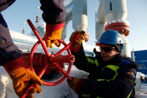 Two men in work clothes turn a red wheel. Two men in work clothes turn a red wheel.