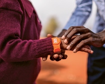 Im Fokus stehen zwei Hände. Um einem Arm ist ein Tap2Eat-Armband umgelegt. Im Fokus stehen zwei Hände. Um einem Arm ist ein Tap2Eat-Armband umgelegt.