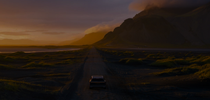 A car in a mountainous landscape driving into the sunset. A car in a mountainous landscape driving into the sunset.