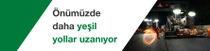 Gece işçiler ve makinelerle yapılan bir yol inşaatı. Metinde şunlar yazıyor: “Gelecekte daha yeşil yollar.”
