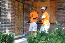Joe Evans and Mark Justice from the BASF site in Wyandotte work to board up vacant homes in the neighborhood of Denby High School.