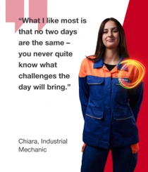 A female BASF employee from Germany in an orange and blue work overall standing against a red background, a light swirl hovers around her shoulder.  The text reads, “What I like about my apprenticeship is that I have so many opportunities. For example, I can travel abroad or get an insight into other careers.”  
