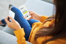 Close-up of woman doing online payments with credit card and her phone