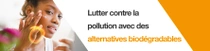 Une femme applique un produit biodégradable sur son visage. Un tourbillon lumineux flotte sur sa main. Le texte indique :  « Lutte contre la pollution avec des alternatives biodégradables. »