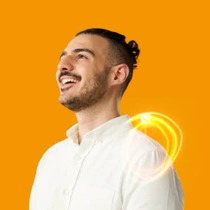 A male BASF employee stands in a white shirt in front of an orange background, laughing. A yellow-orange light swirl hovers behind his shoulder.