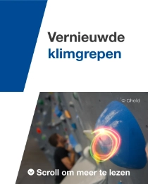 Close-up van een blauwe klimgreep op een indoorwand, met een klimmer op de achtergrond die wazig is.