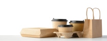 Fast food packaging set. Paper coffee cups in holder, food box, brown paper bag isolated over white Fast food packaging set. Paper coffee cups in holder, food box, brown paper bag isolated over white
